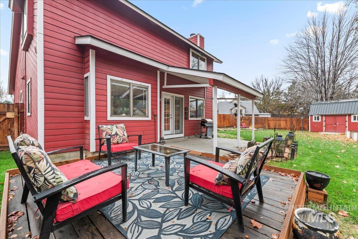 Wooden terrace with a fenced backyard, french doors, a patio area, a shed, and a grill