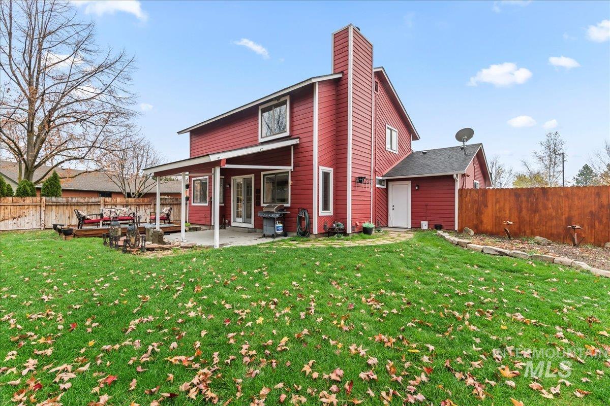 Back of property with a fenced backyard, a patio area, and a chimney