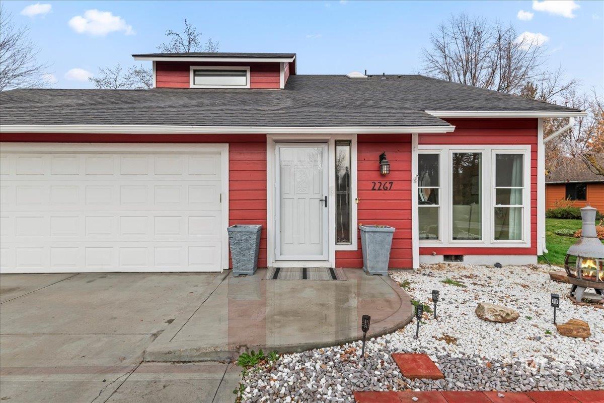 View of front facade with roof with shingles, concrete driveway, and an attached garage