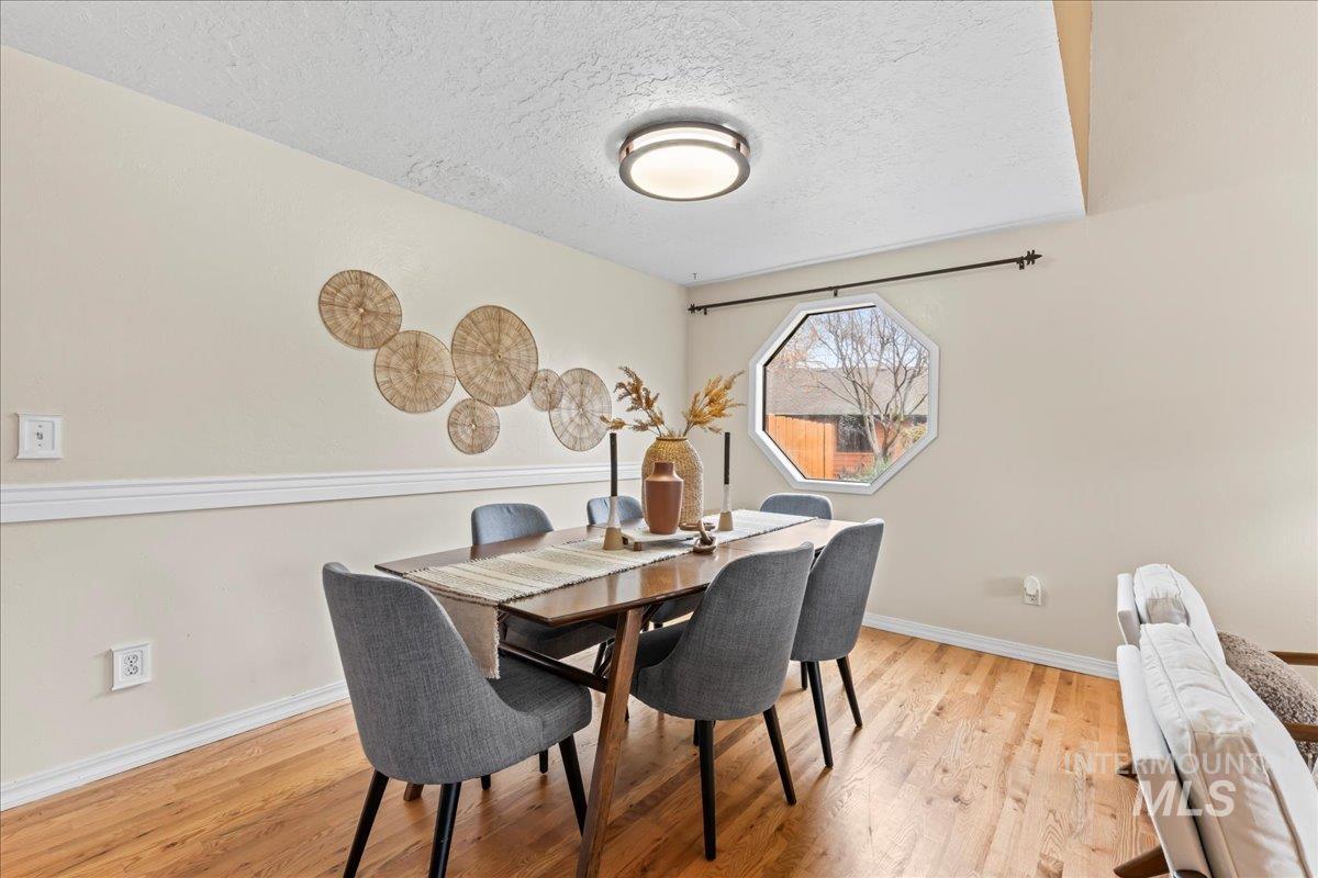 Dining area featuring a textured ceiling and light wood-style floors
