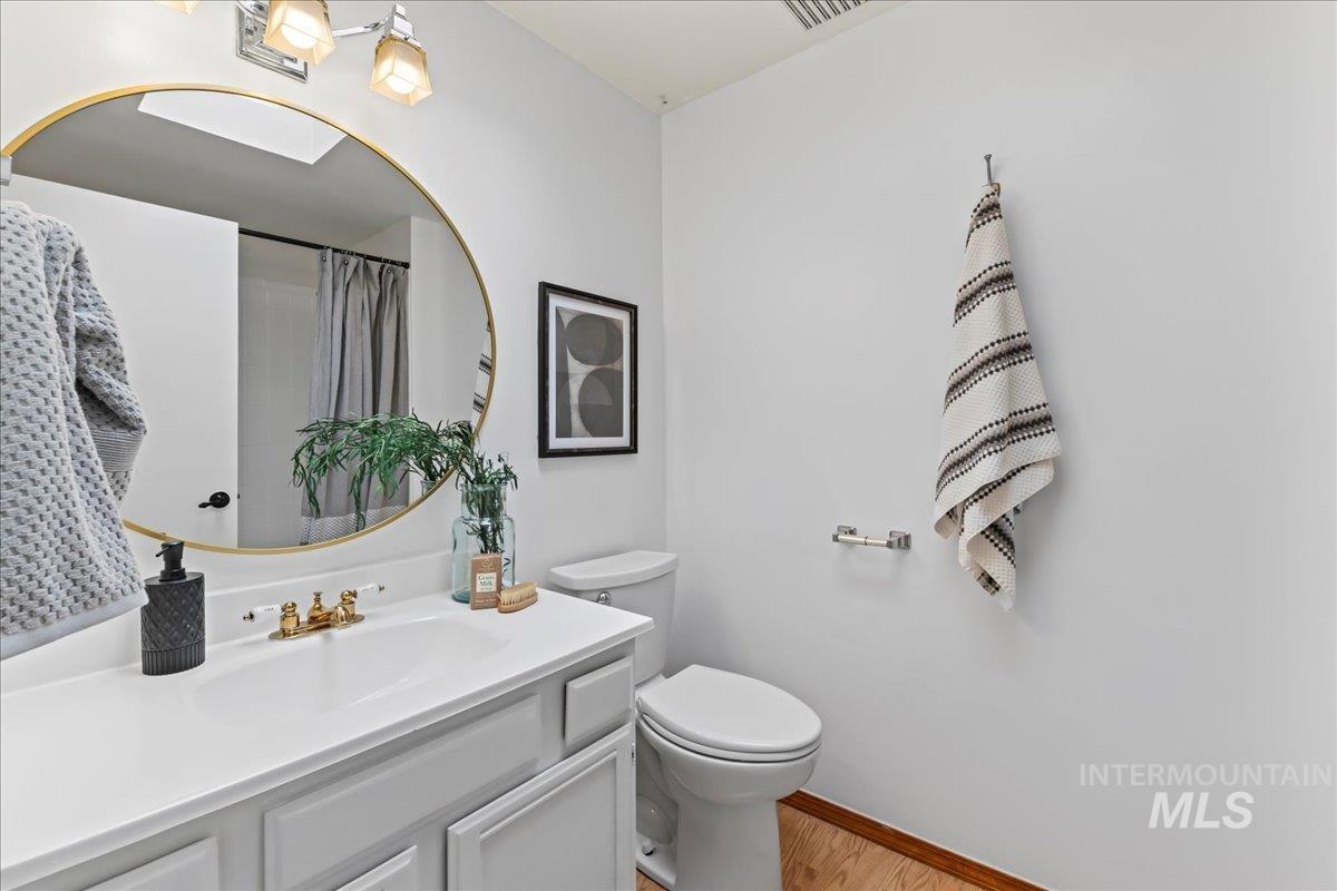 Bathroom with vanity, a shower with shower curtain, and light wood-style floors