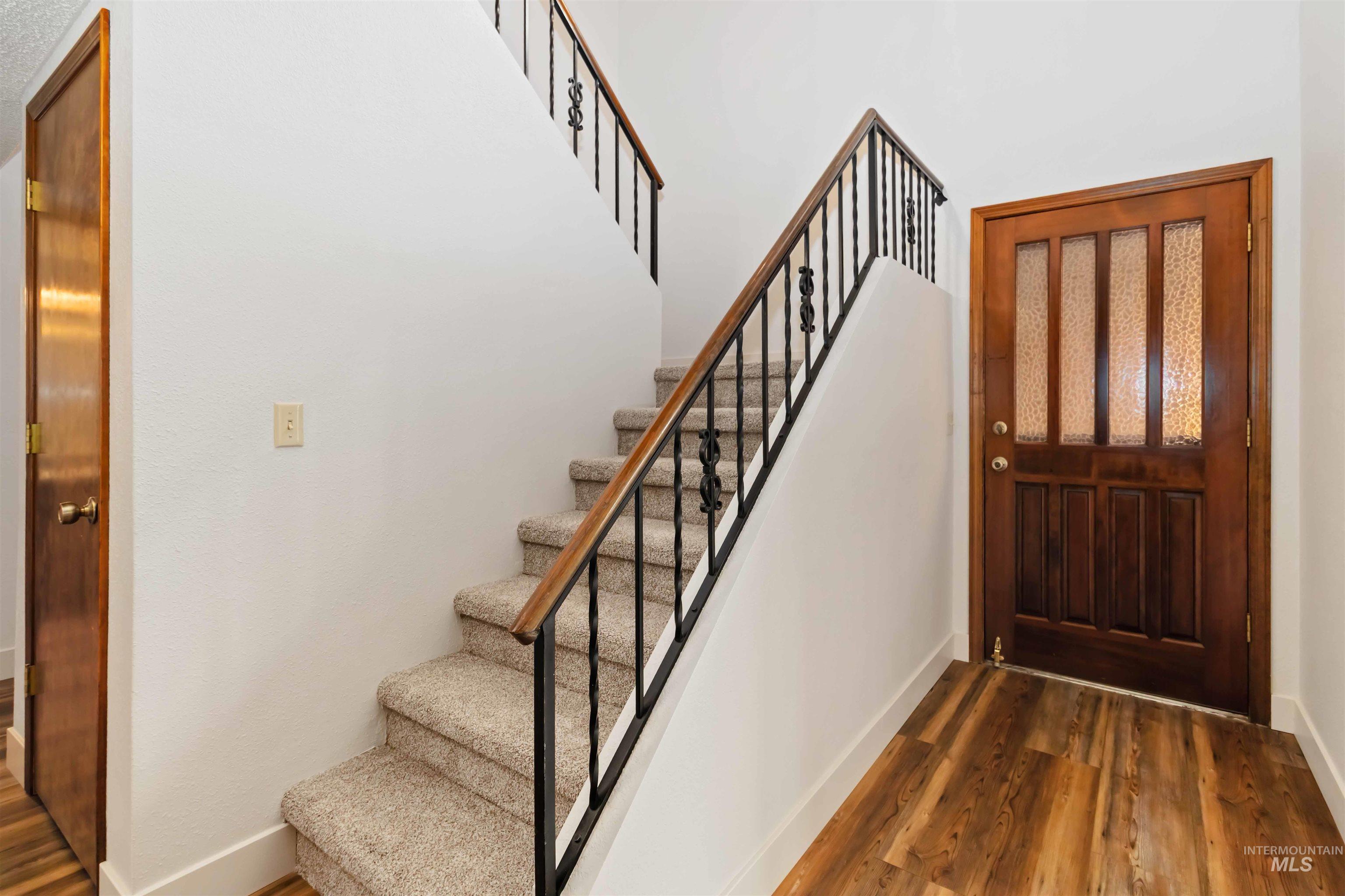 Stairway with wood finished floors and baseboards