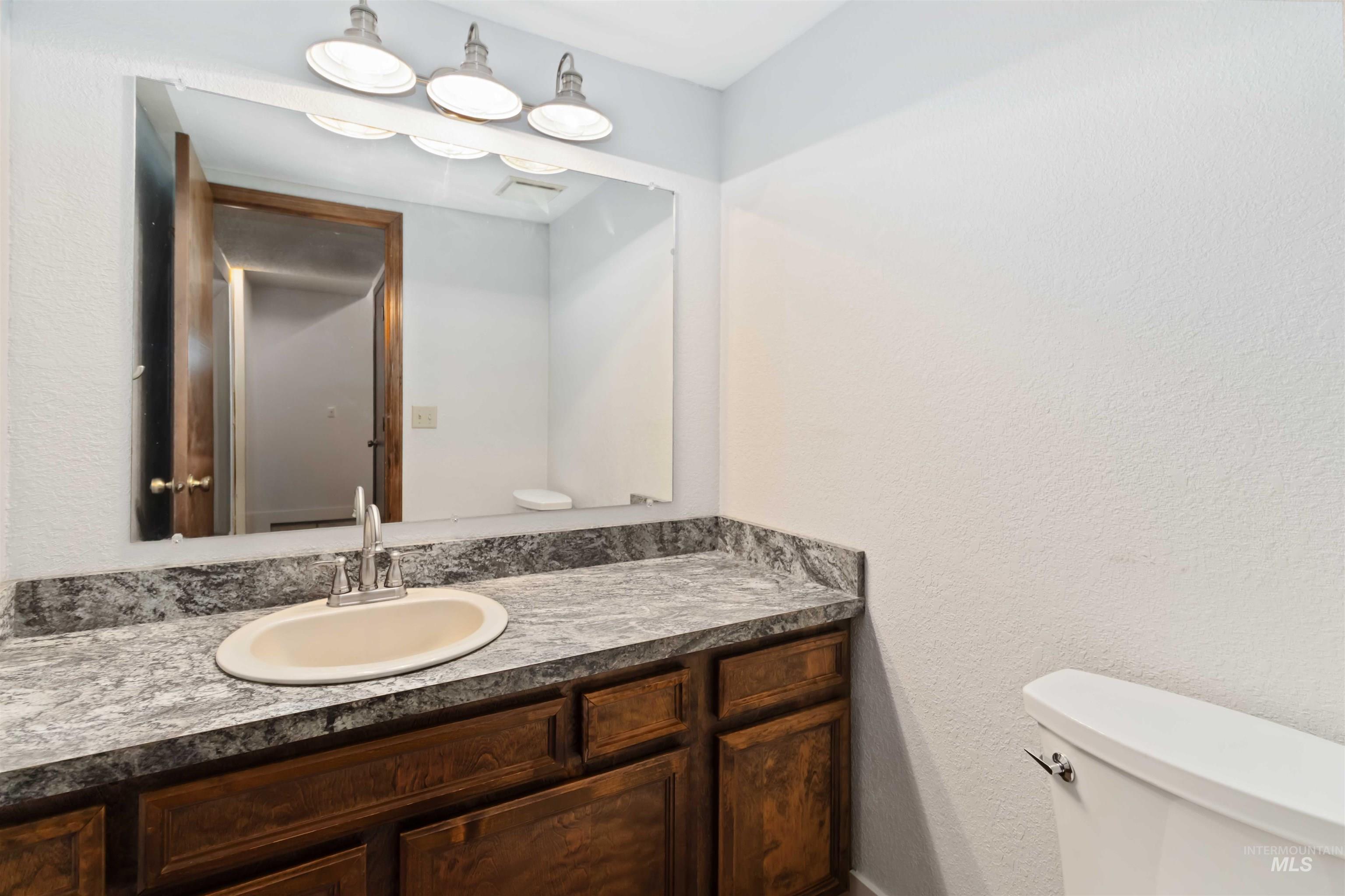 Bathroom featuring vanity and a textured wall