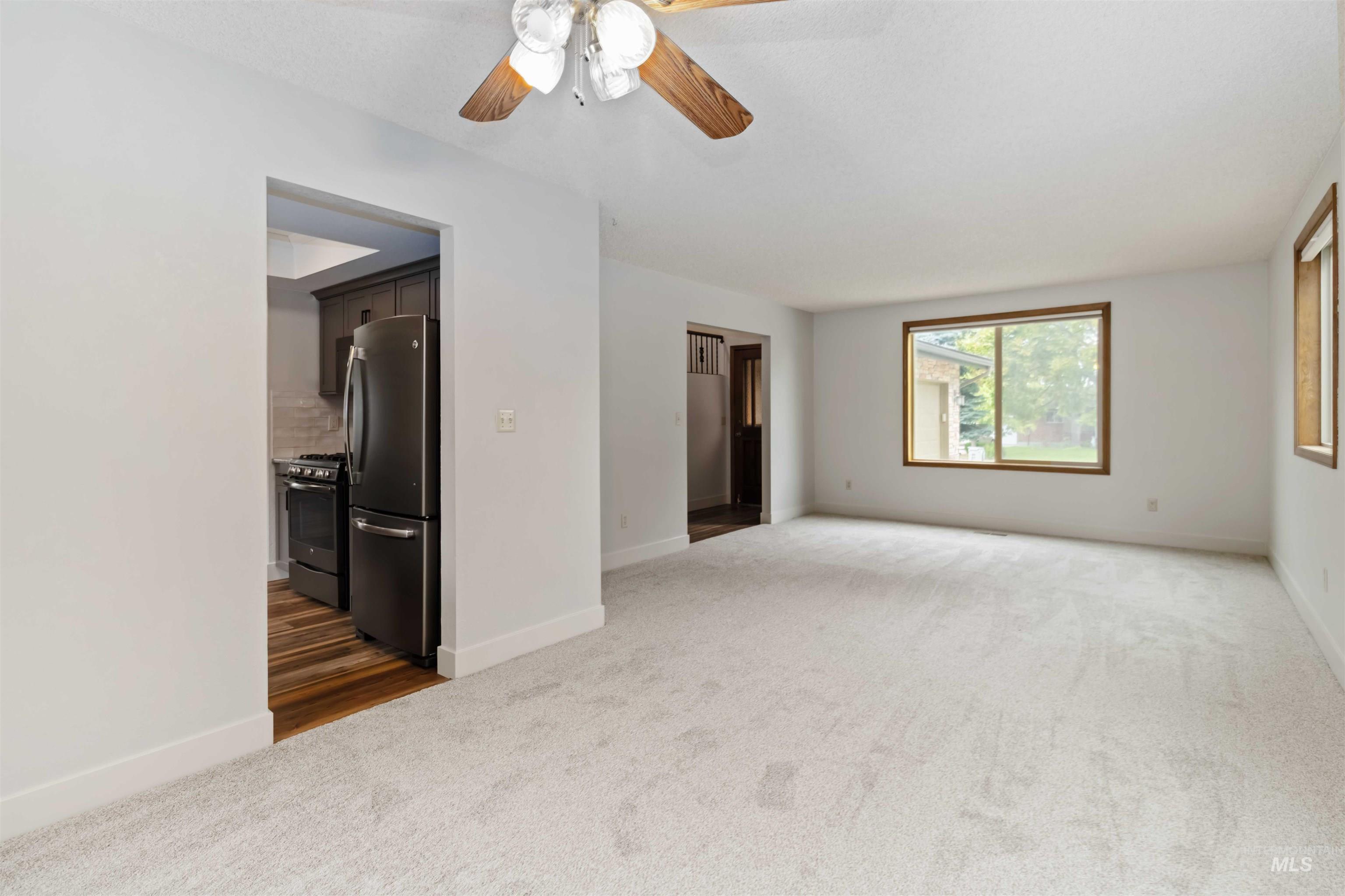 Spare room featuring dark carpet and a ceiling fan
