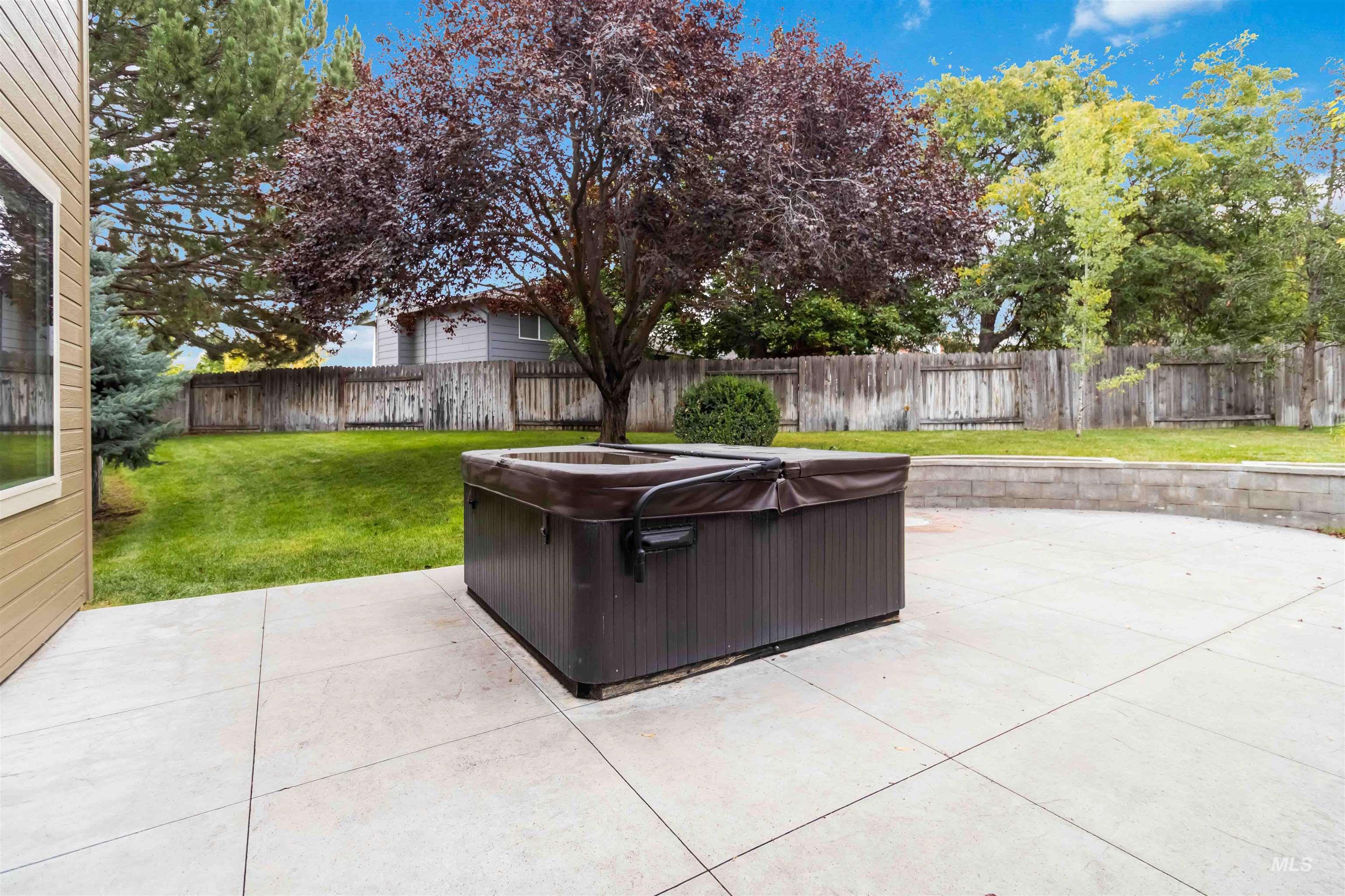 Fenced backyard with a patio and a hot tub