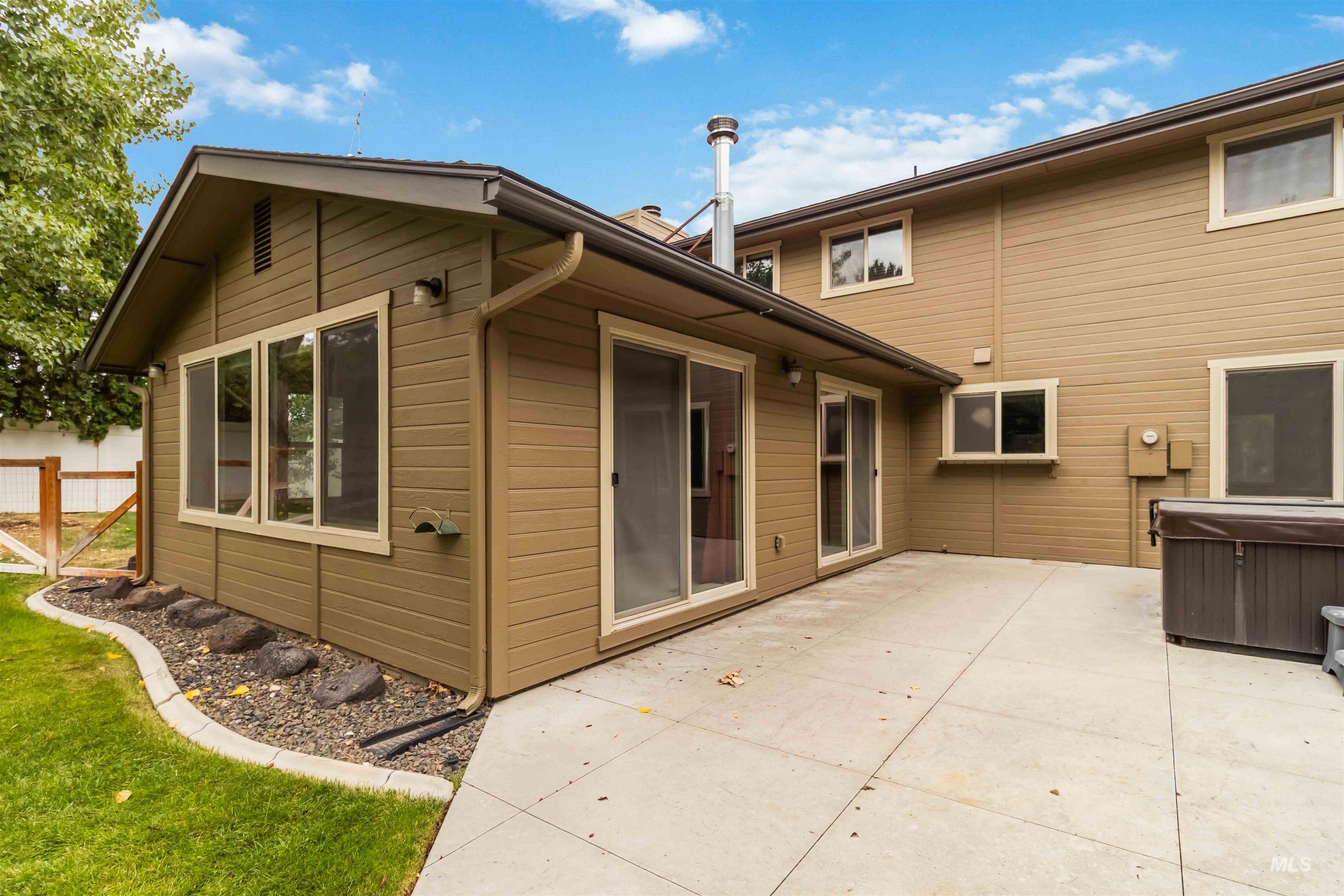 Back of house featuring a patio area and a hot tub