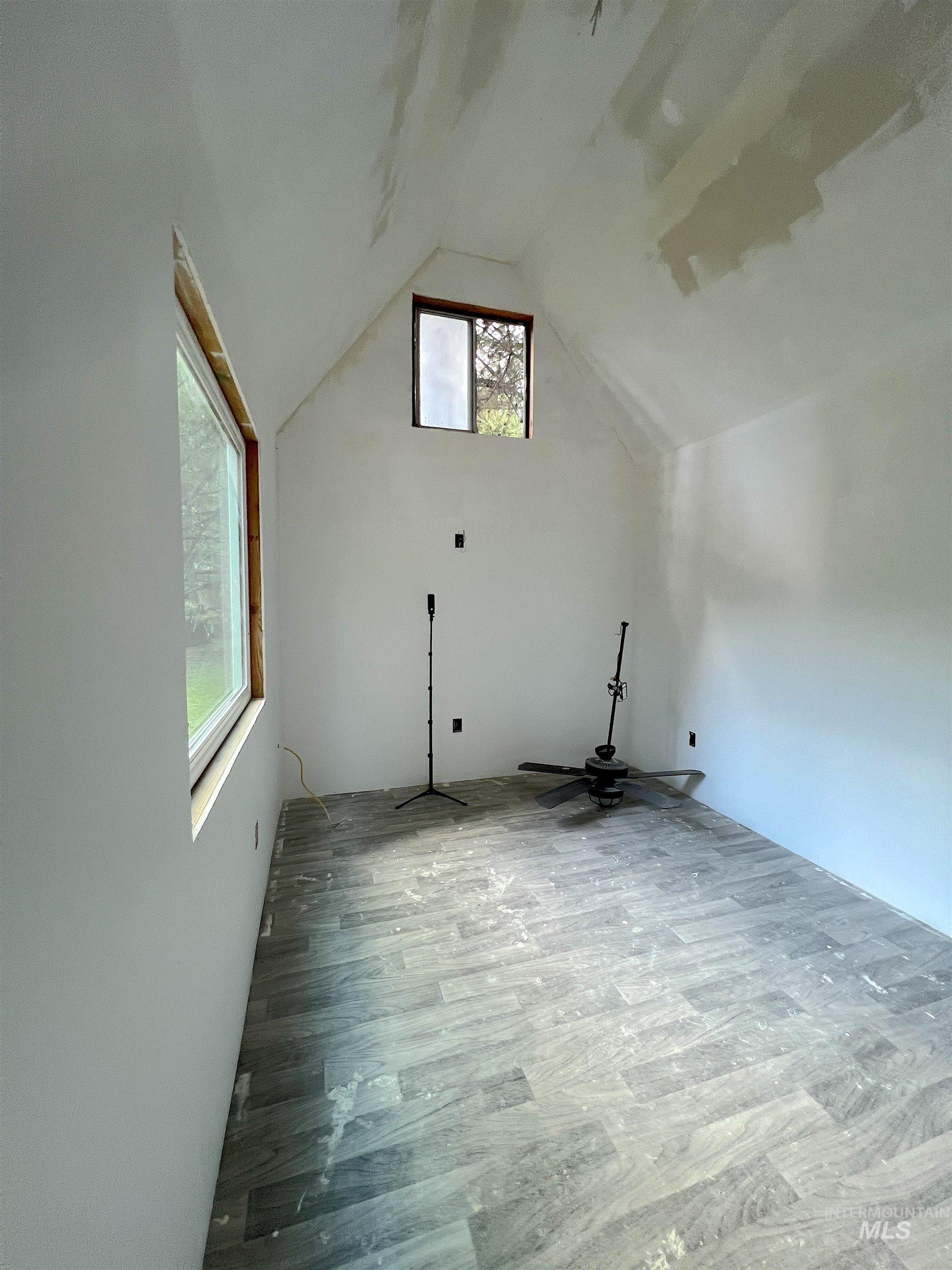 Additional living space with wood finished floors and vaulted ceiling