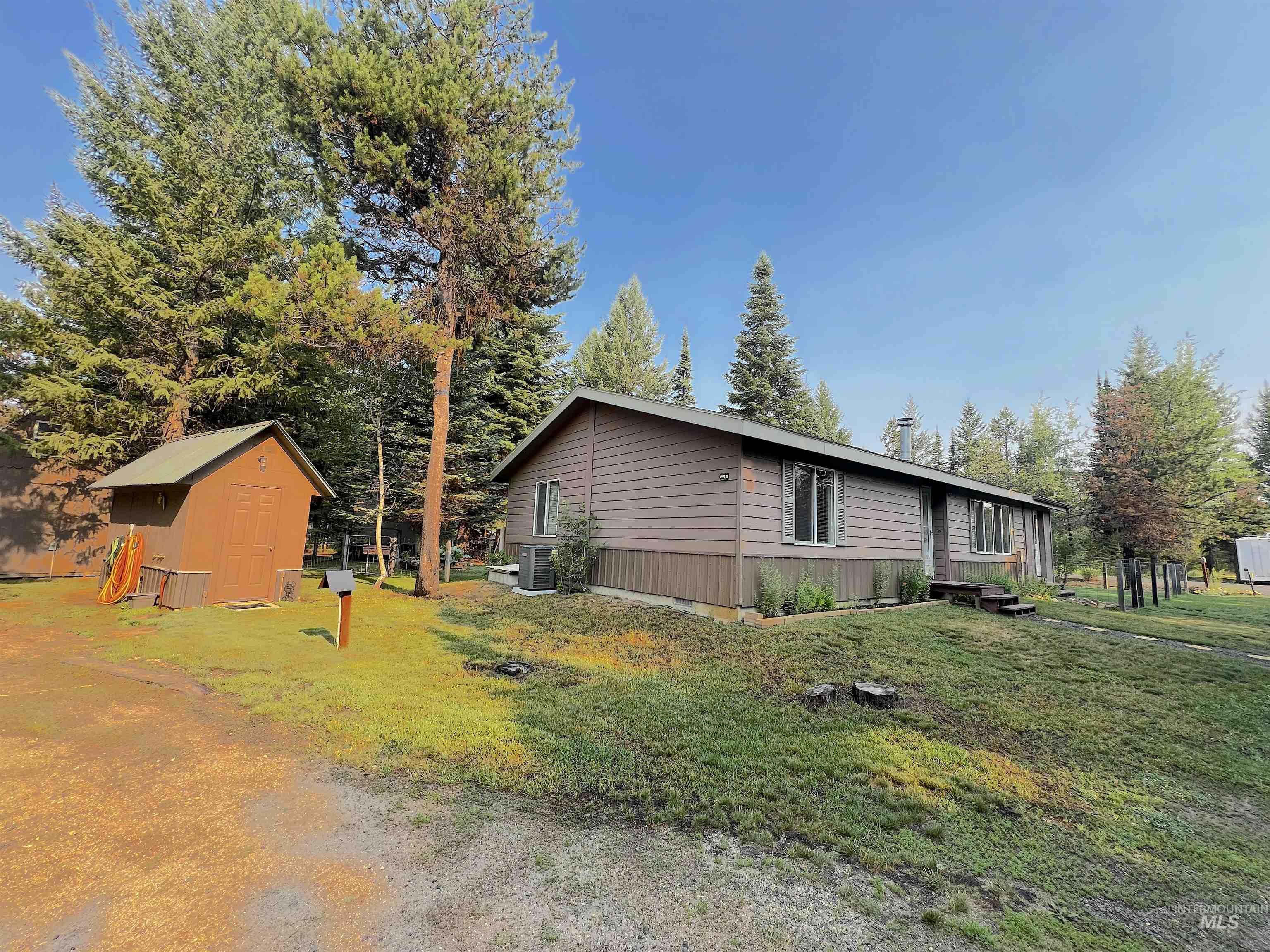 View of side of home with a storage shed and a yard
