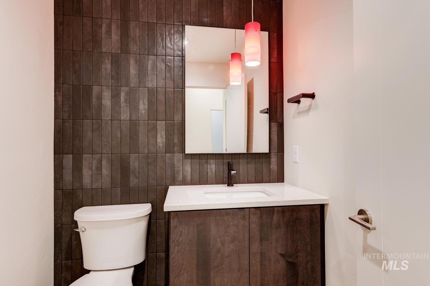 Half bath with tile walls and vanity