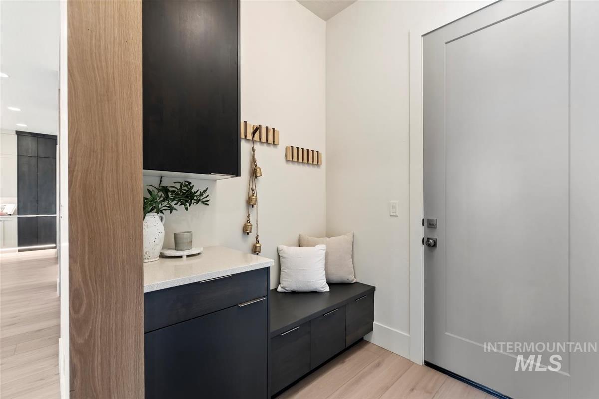 Mudroom with light wood-style floors and baseboards