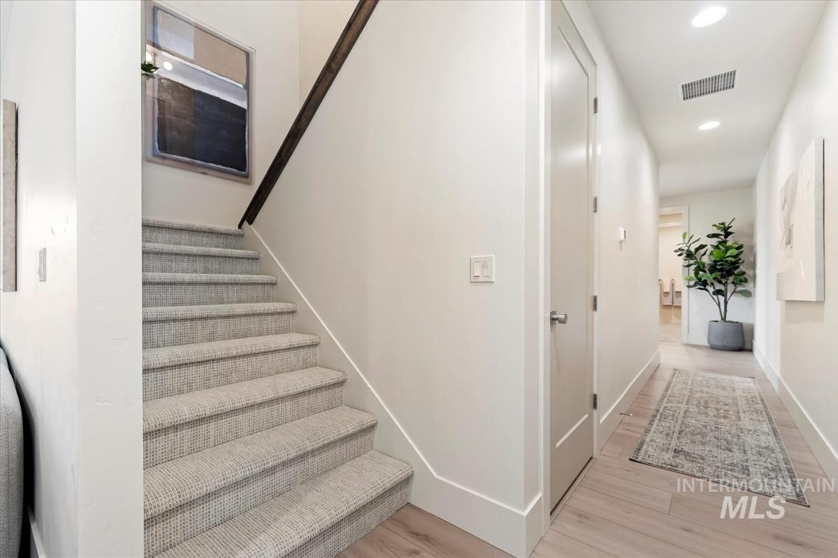 Stairway featuring recessed lighting and wood finished floors