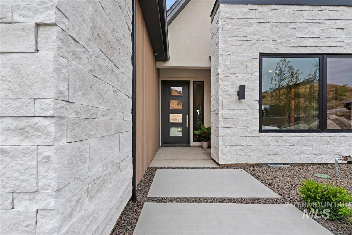 View of exterior entry with stone siding and stucco siding