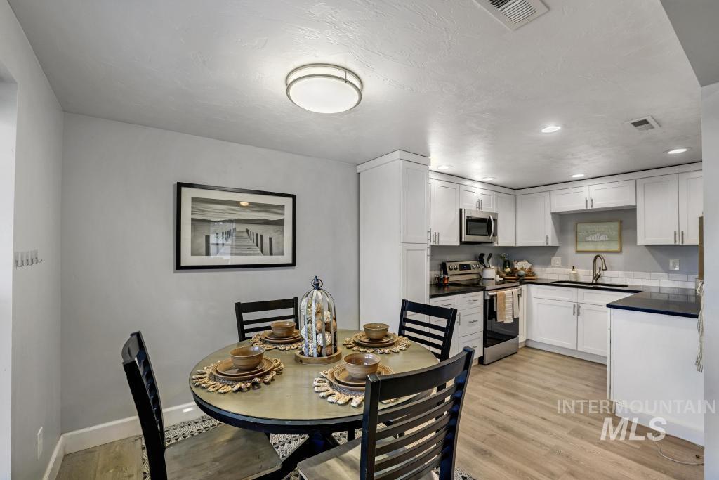 Dining room with light wood-type flooring, recessed lighting, and a textured ceiling