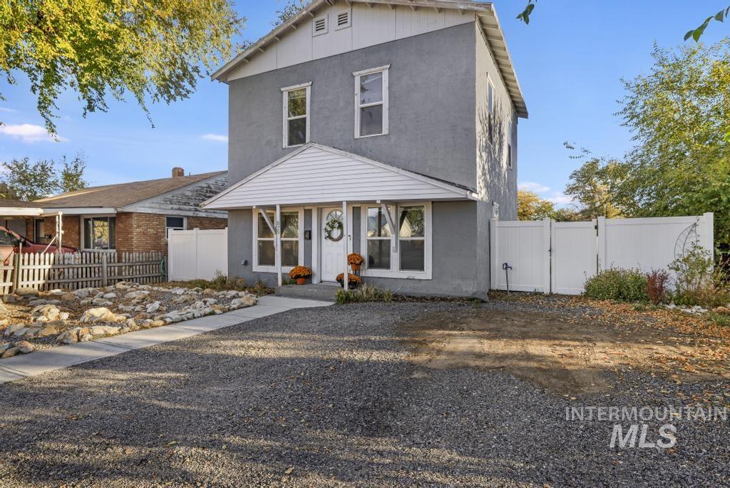 View of front of home featuring stucco siding and a gate