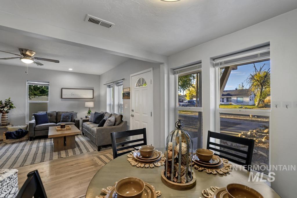 Dining room featuring wood finished floors, a ceiling fan, and beam ceiling