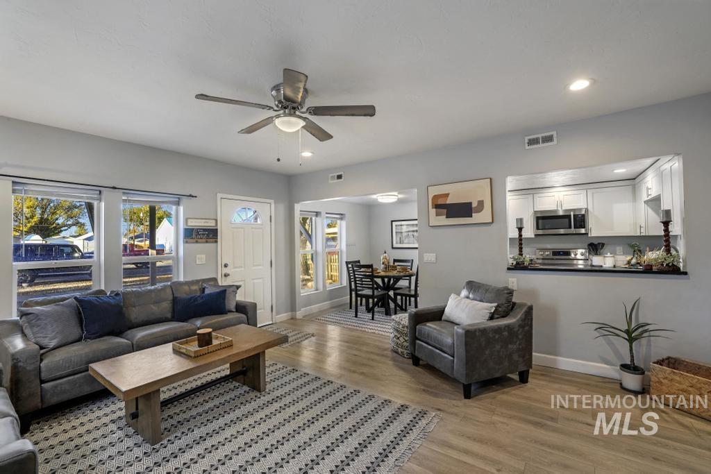 Living room with light wood-style floors, recessed lighting, plenty of natural light, and a ceiling fan