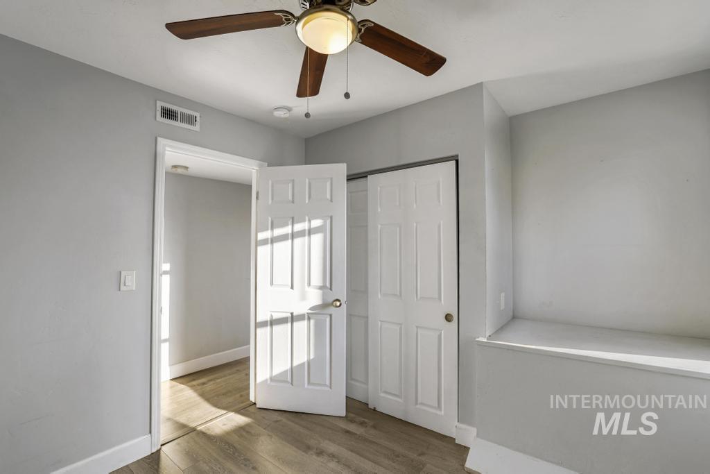 Unfurnished bedroom with wood finished floors, a closet, and ceiling fan