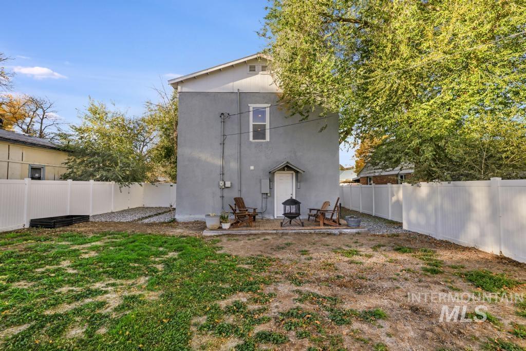 Rear view of property featuring a patio area, a fenced backyard, and stucco siding