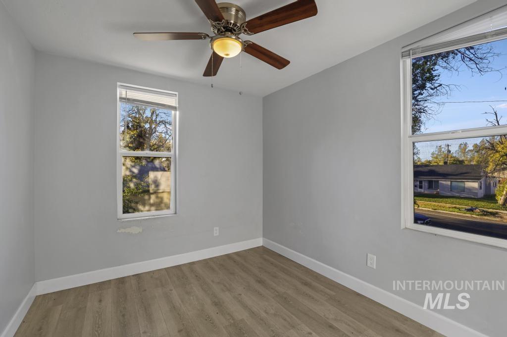 Empty room with wood finished floors and a ceiling fan