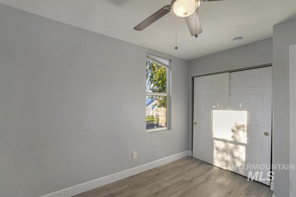 Unfurnished bedroom featuring a closet, light wood-type flooring, and a ceiling fan
