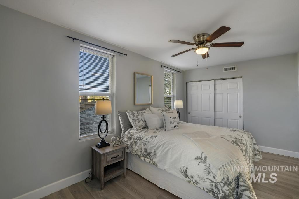 Bedroom with wood finished floors, a closet, and ceiling fan