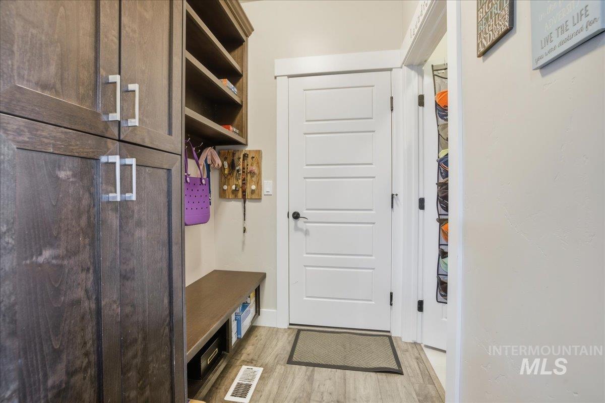 Mudroom with light wood finished floors and baseboards