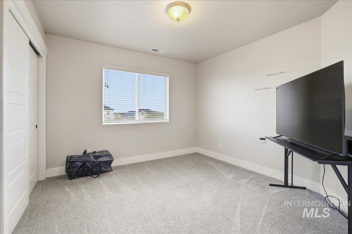 Unfurnished bedroom featuring light carpet and a closet