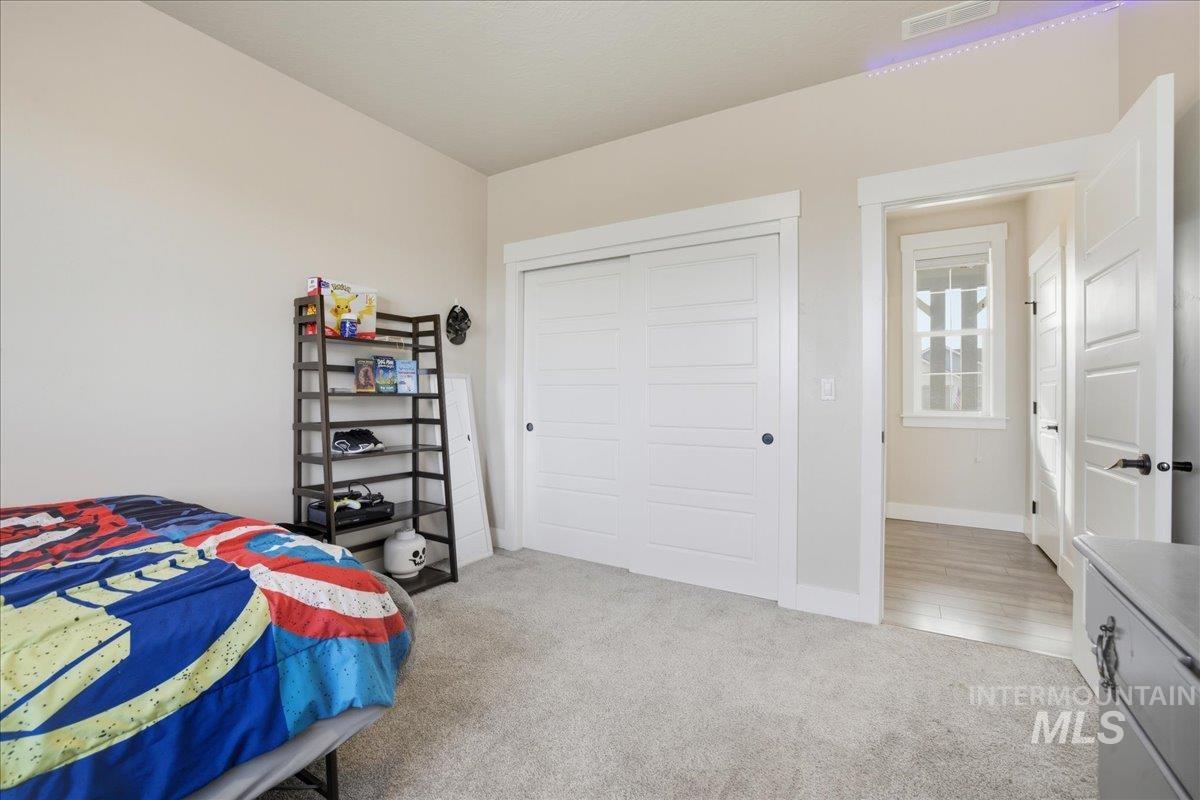 Bedroom featuring light carpet and a closet