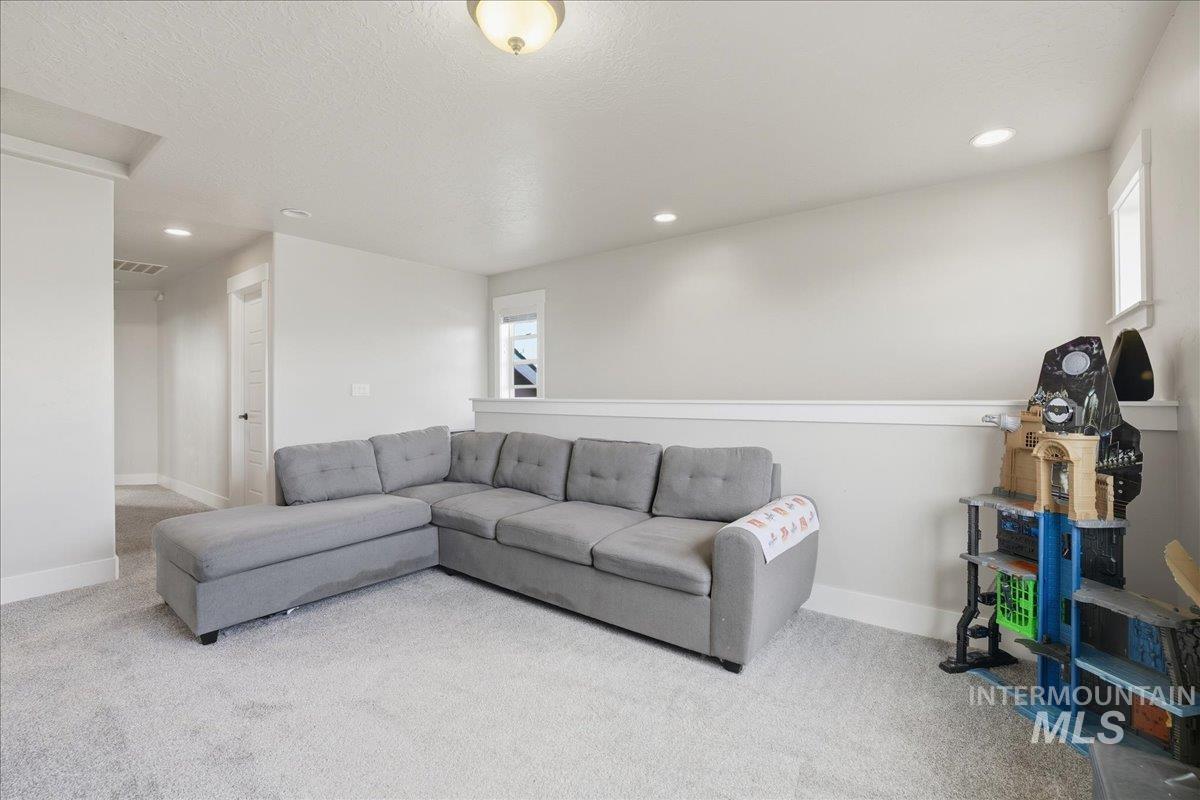 Living room featuring carpet floors, recessed lighting, and a textured ceiling