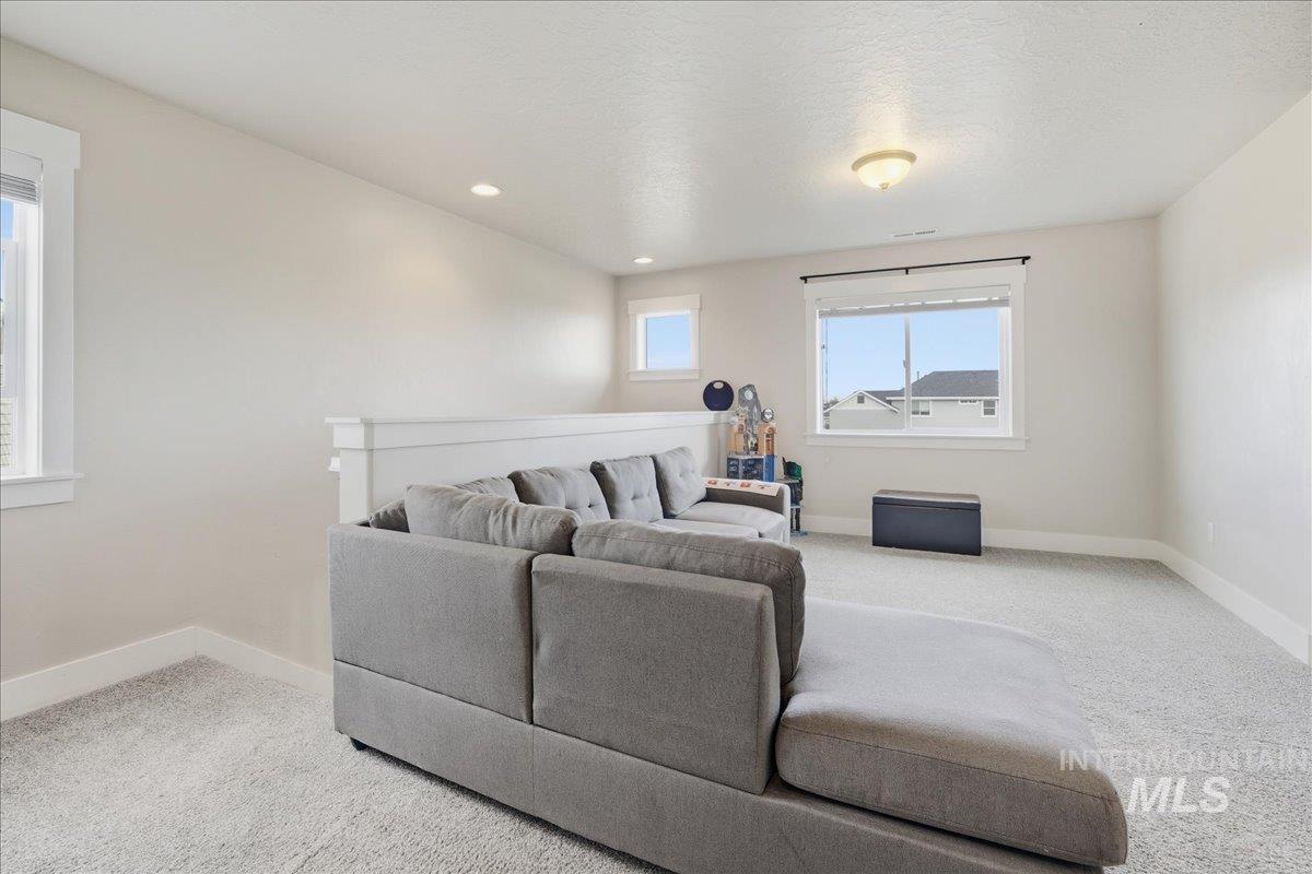 Living room with light carpet, recessed lighting, and a textured ceiling