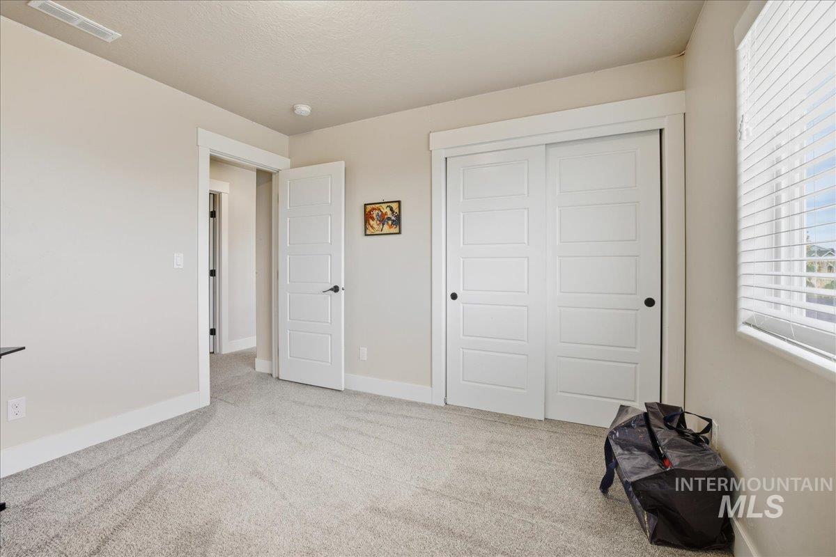 Unfurnished bedroom with light carpet and a closet