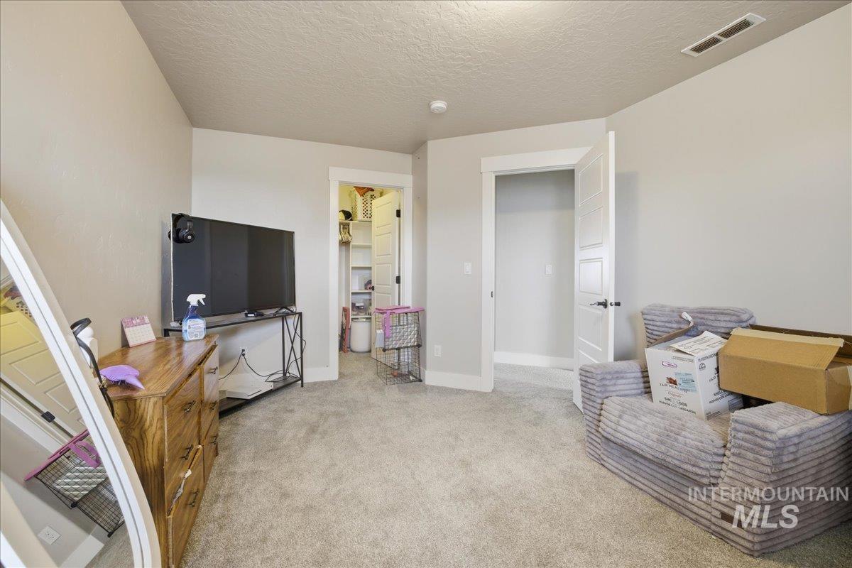 Living area with light colored carpet and a textured ceiling