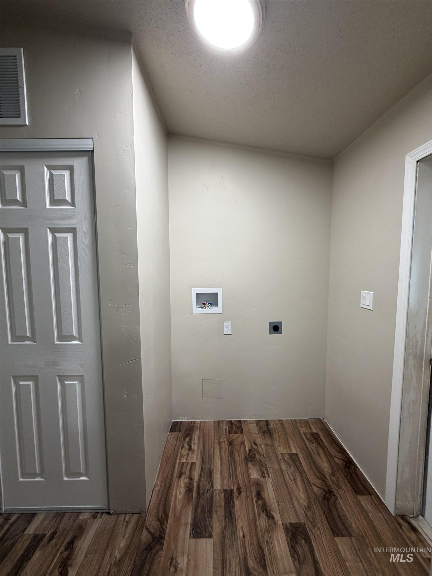 Laundry room featuring dark wood-style floors, washer hookup, a textured ceiling, and electric dryer hookup
