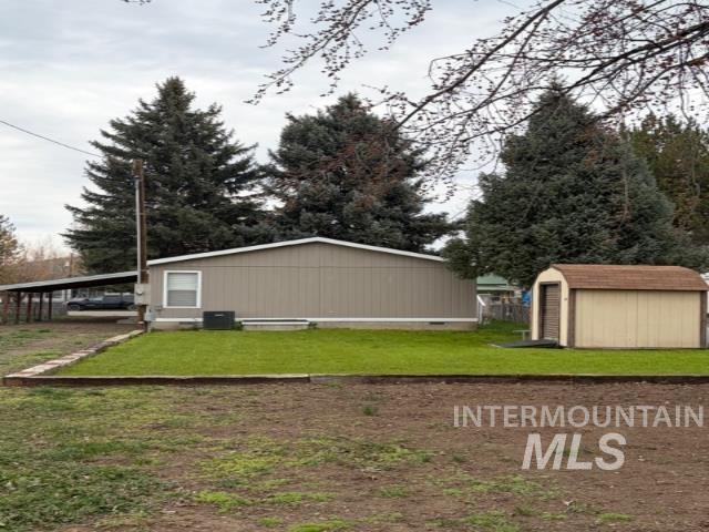 View of grassy yard featuring a storage unit
