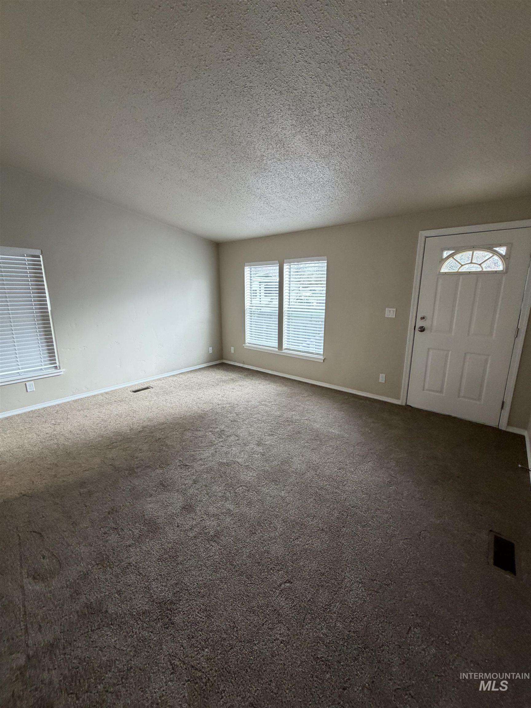 Foyer with carpet and a textured ceiling