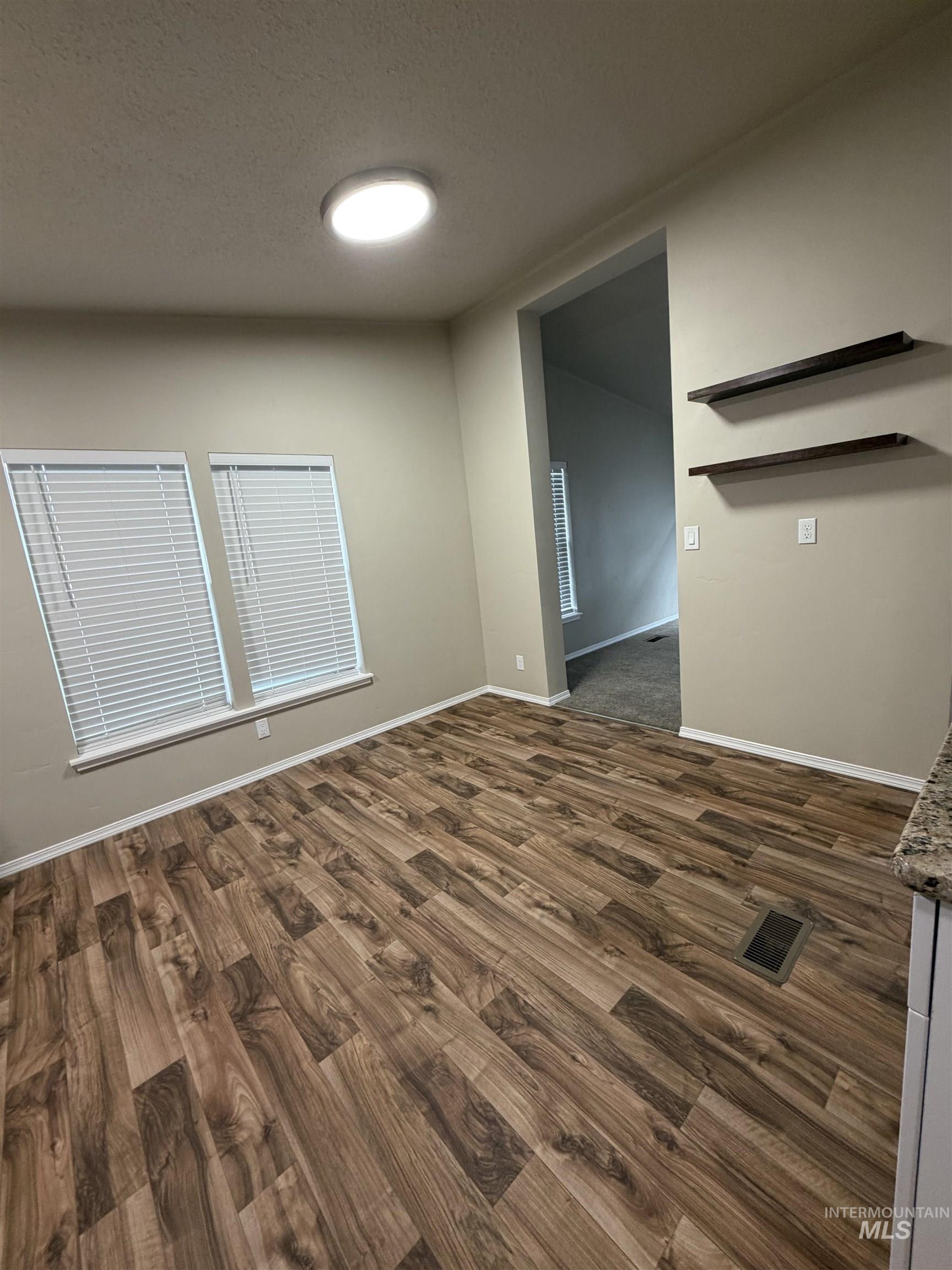 Unfurnished room with dark wood-style floors and a textured ceiling