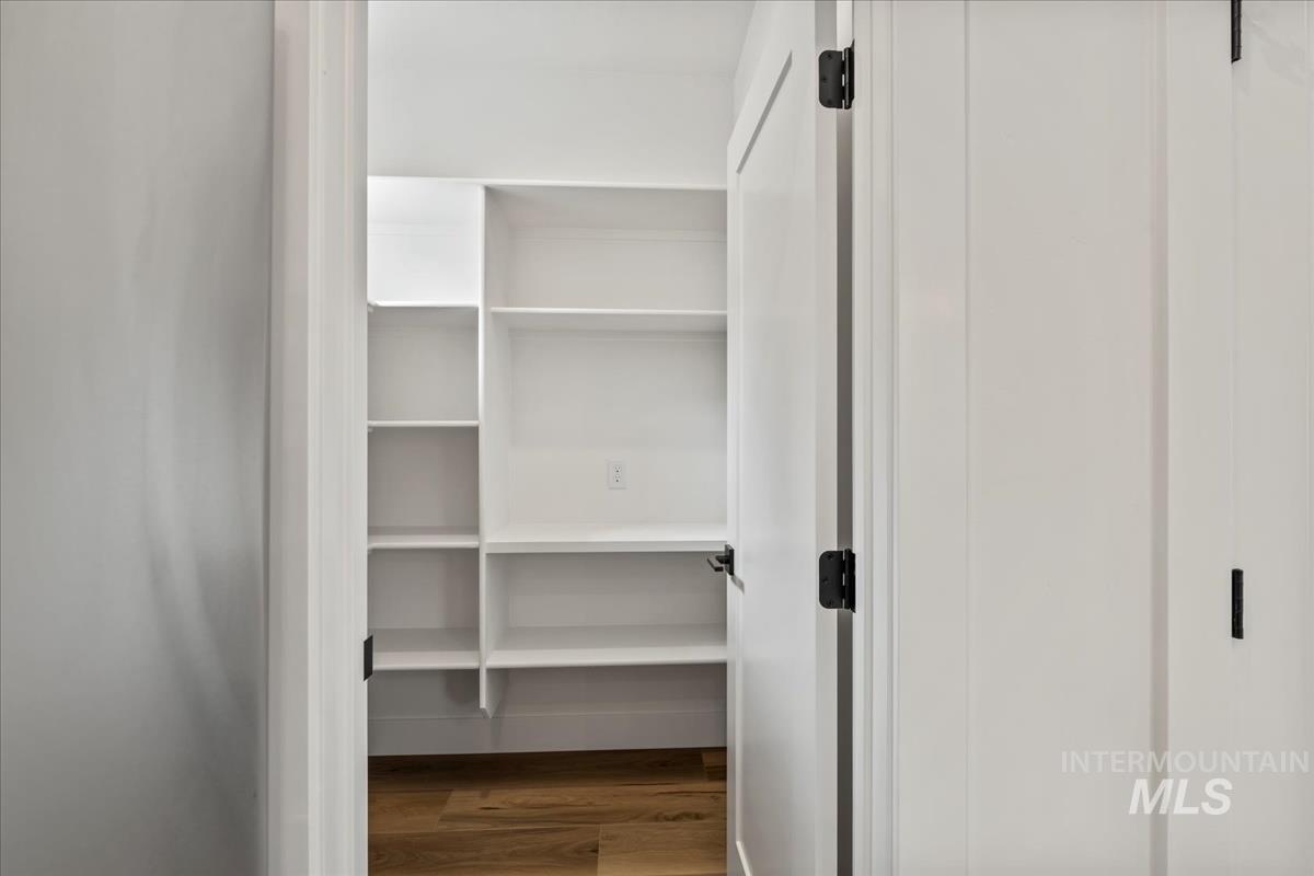 Spacious closet featuring dark wood-style flooring