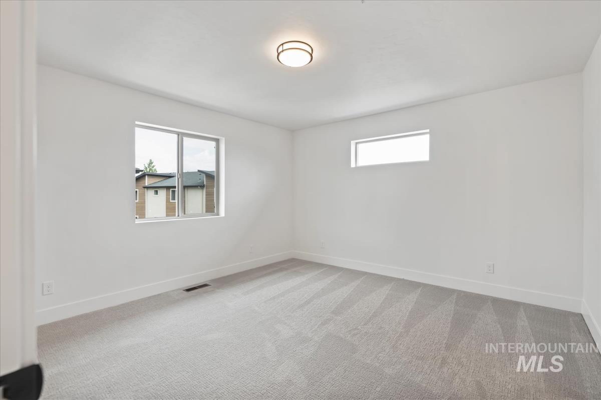 Empty room with light carpet and baseboards