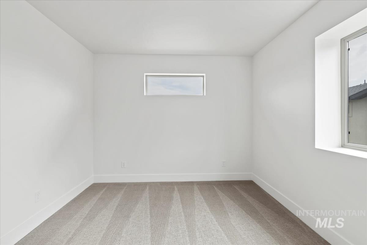 Spare room with light colored carpet and baseboards