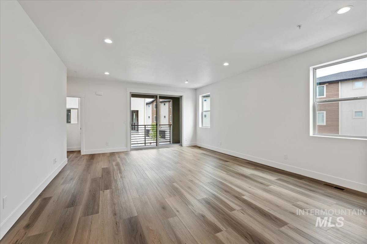 Spare room featuring plenty of natural light, recessed lighting, and light wood-type flooring
