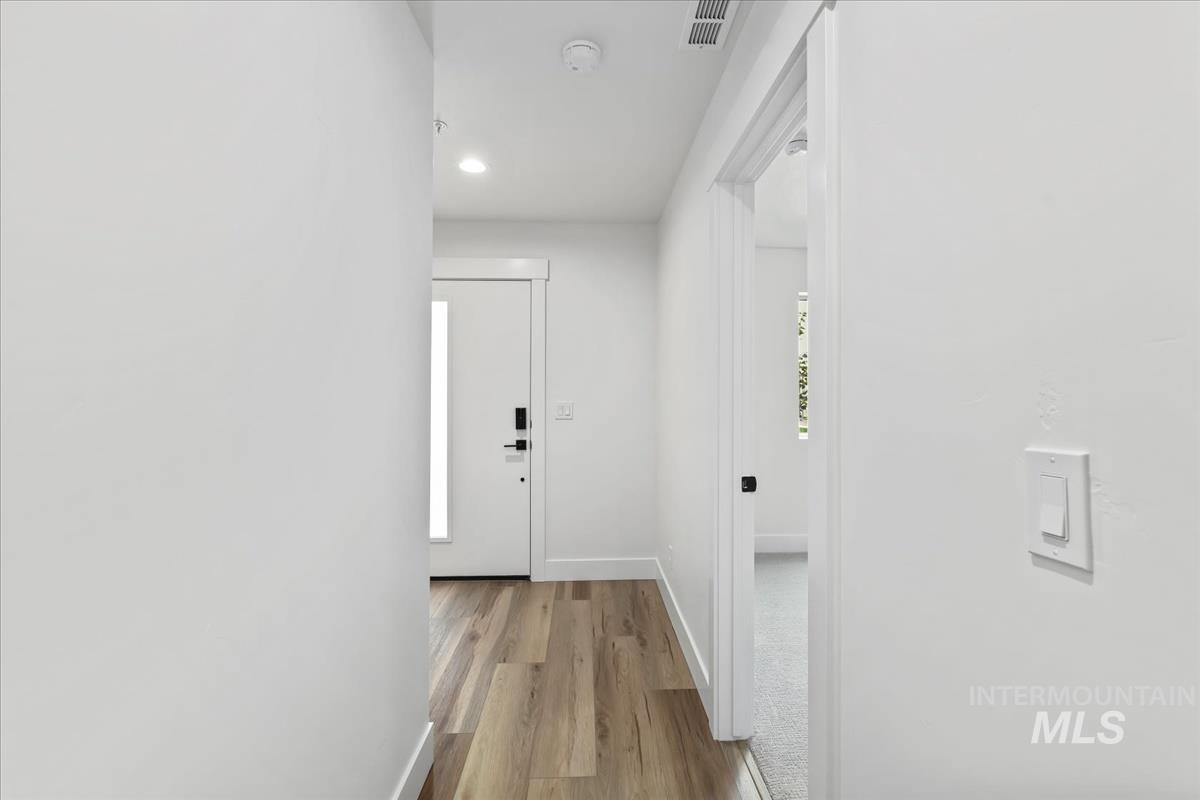 Corridor featuring light wood-style flooring and recessed lighting