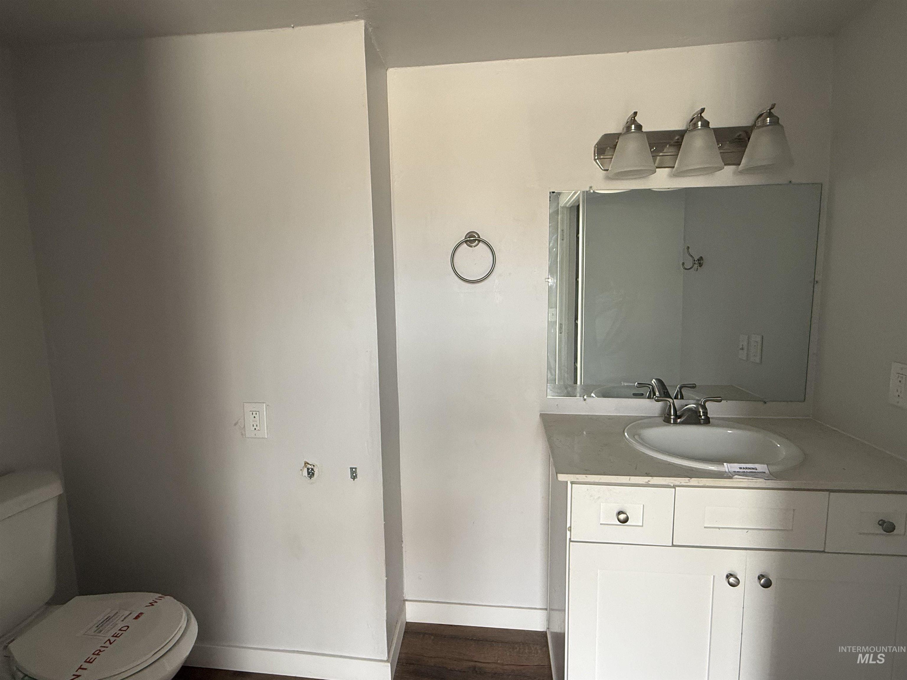 Half bath with vanity and dark wood finished floors