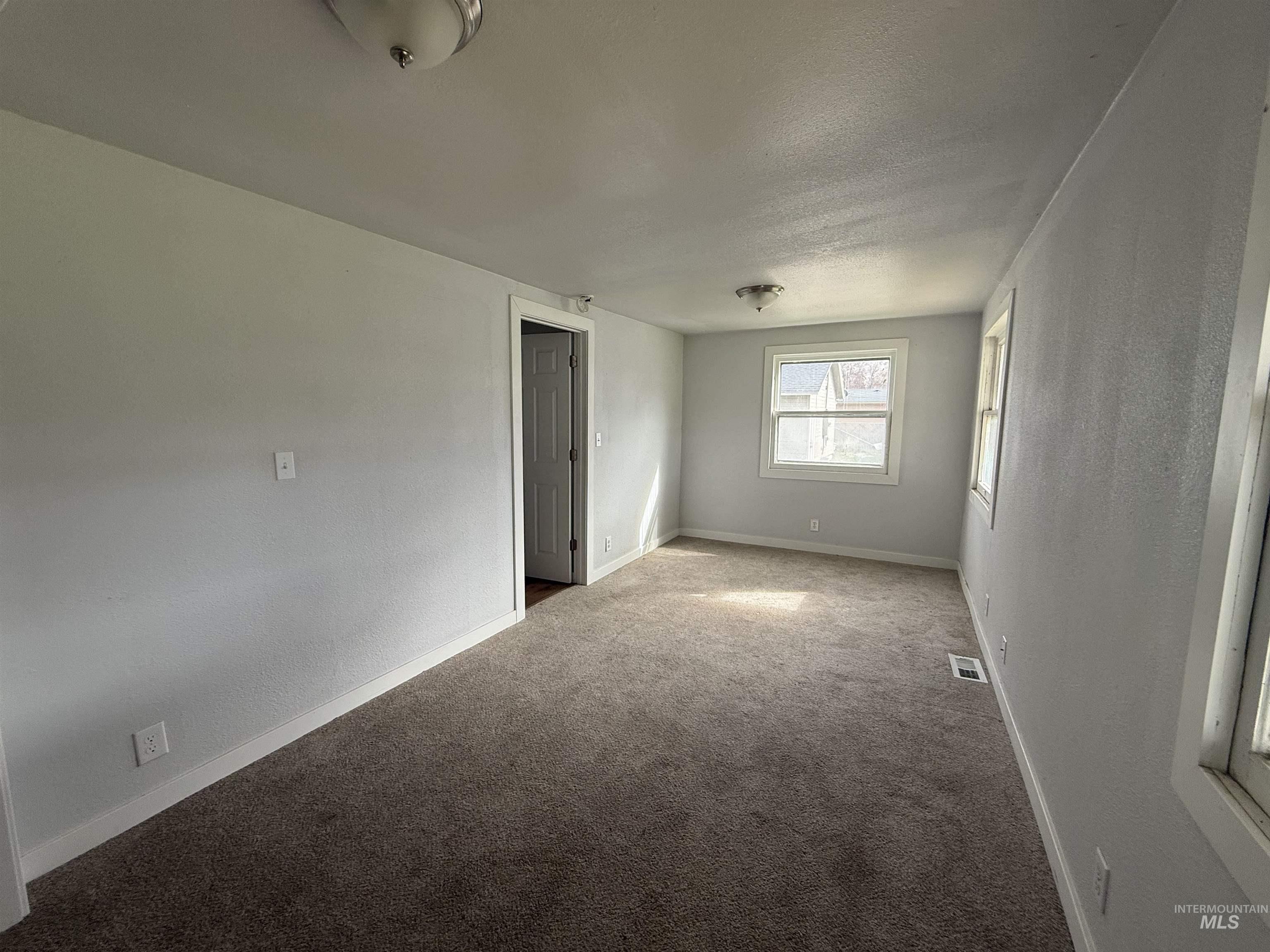 Empty room with a textured wall and carpet floors