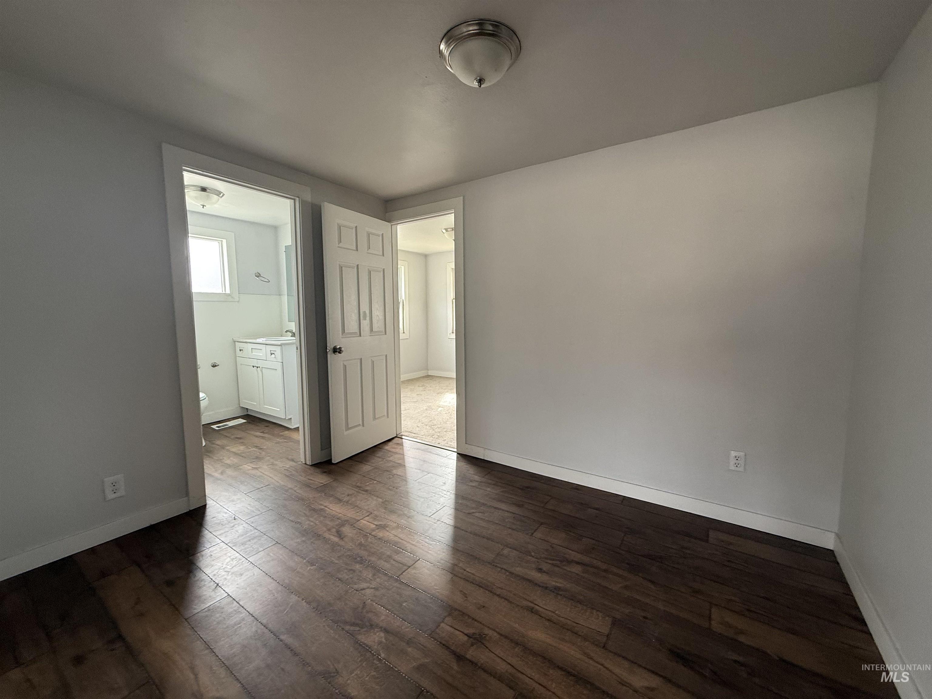 Unfurnished room featuring dark wood-type flooring