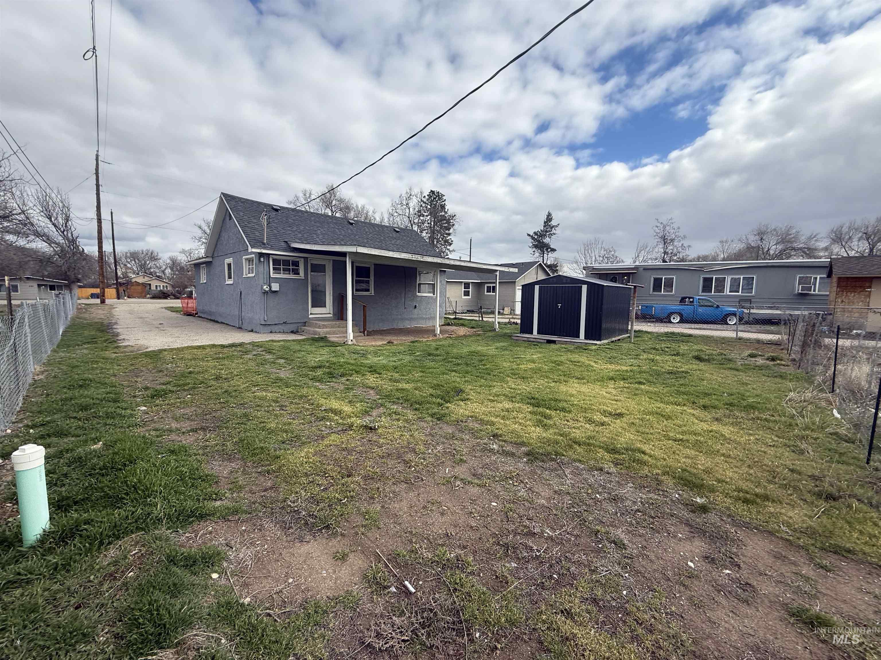 Rear view of house with a fenced backyard, a storage shed, a patio, and a shingled roof