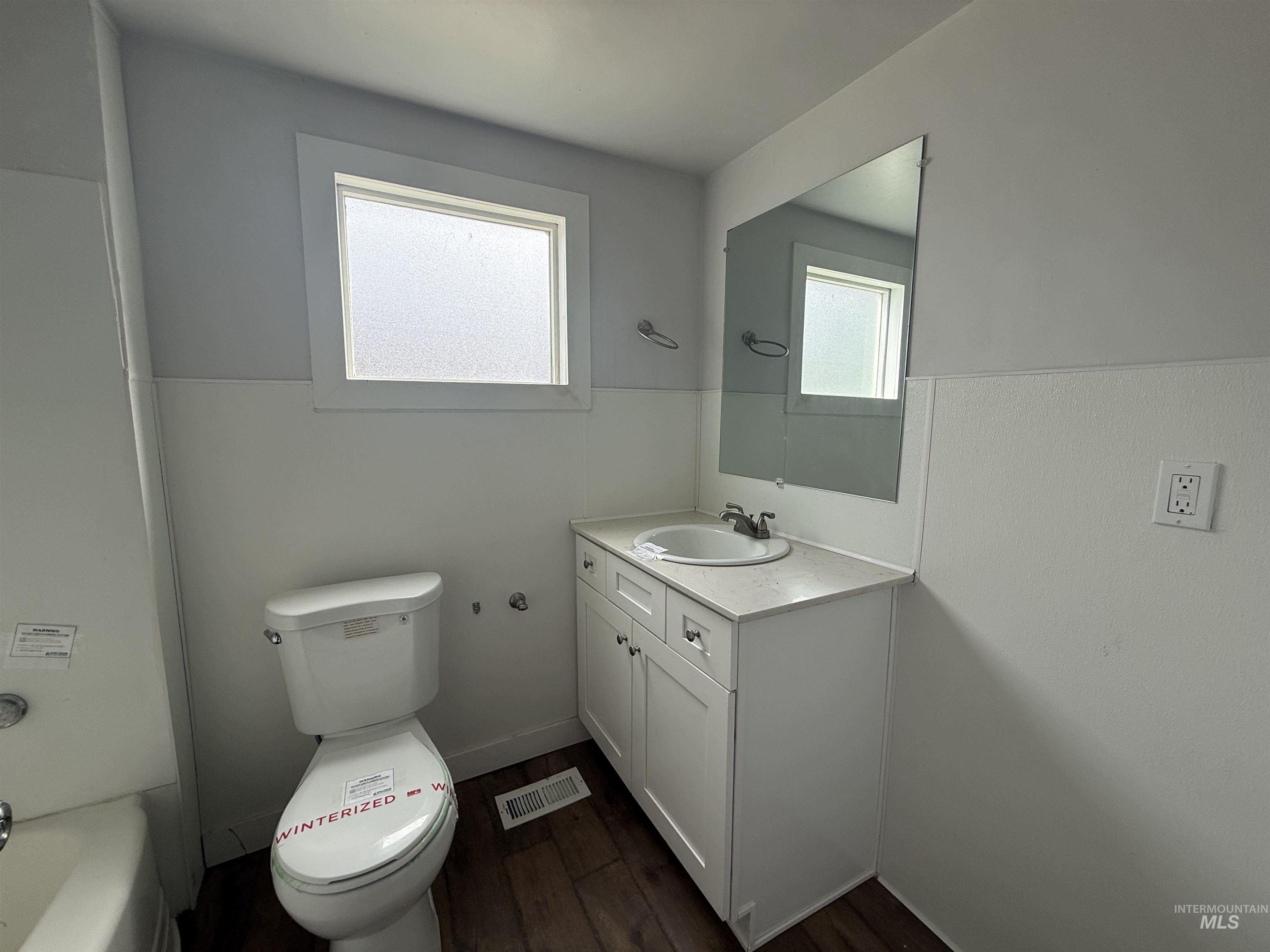 Full bath with vanity, dark wood finished floors, and bathing tub / shower combination