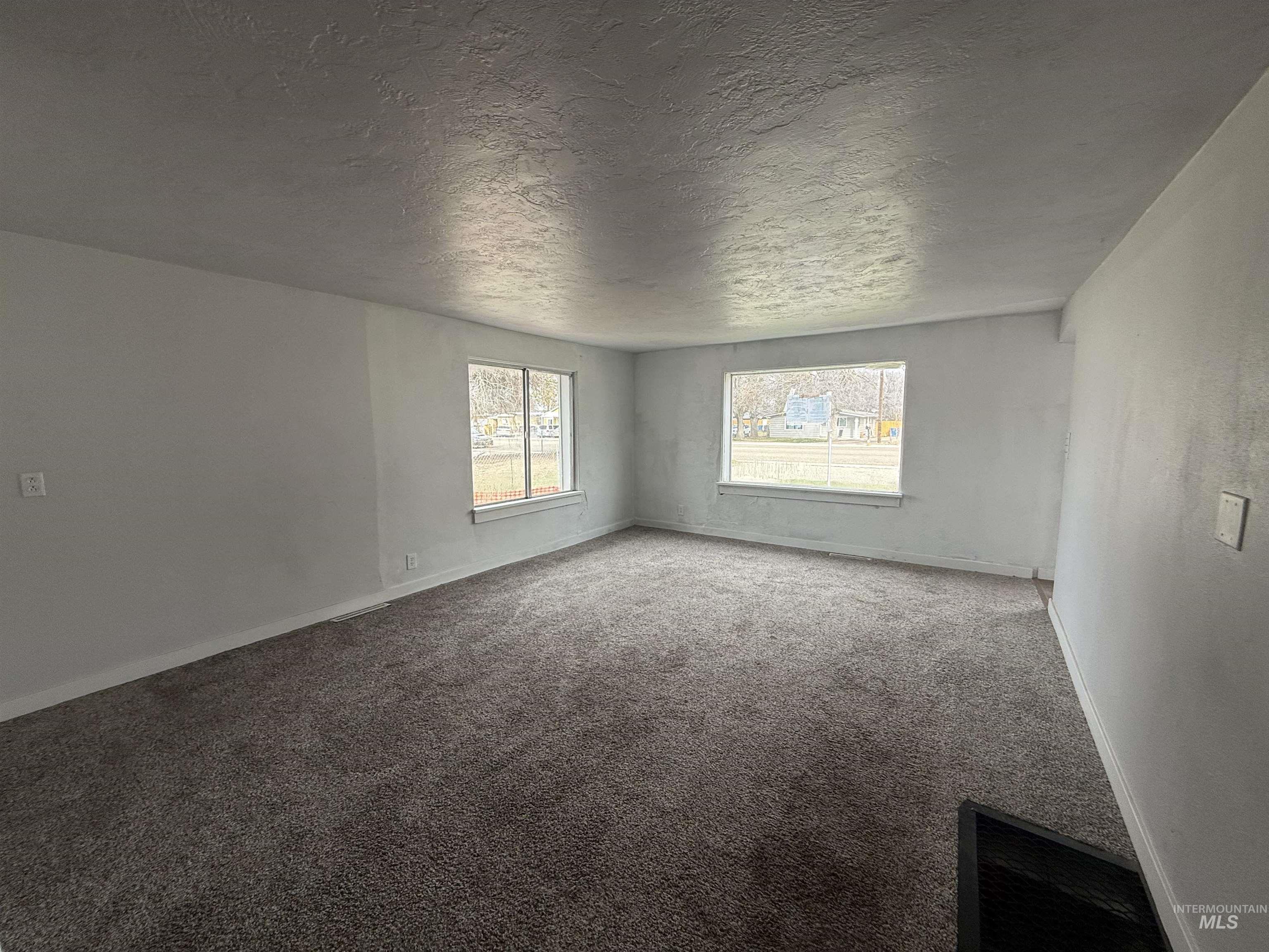 Empty room featuring carpet floors and a textured ceiling