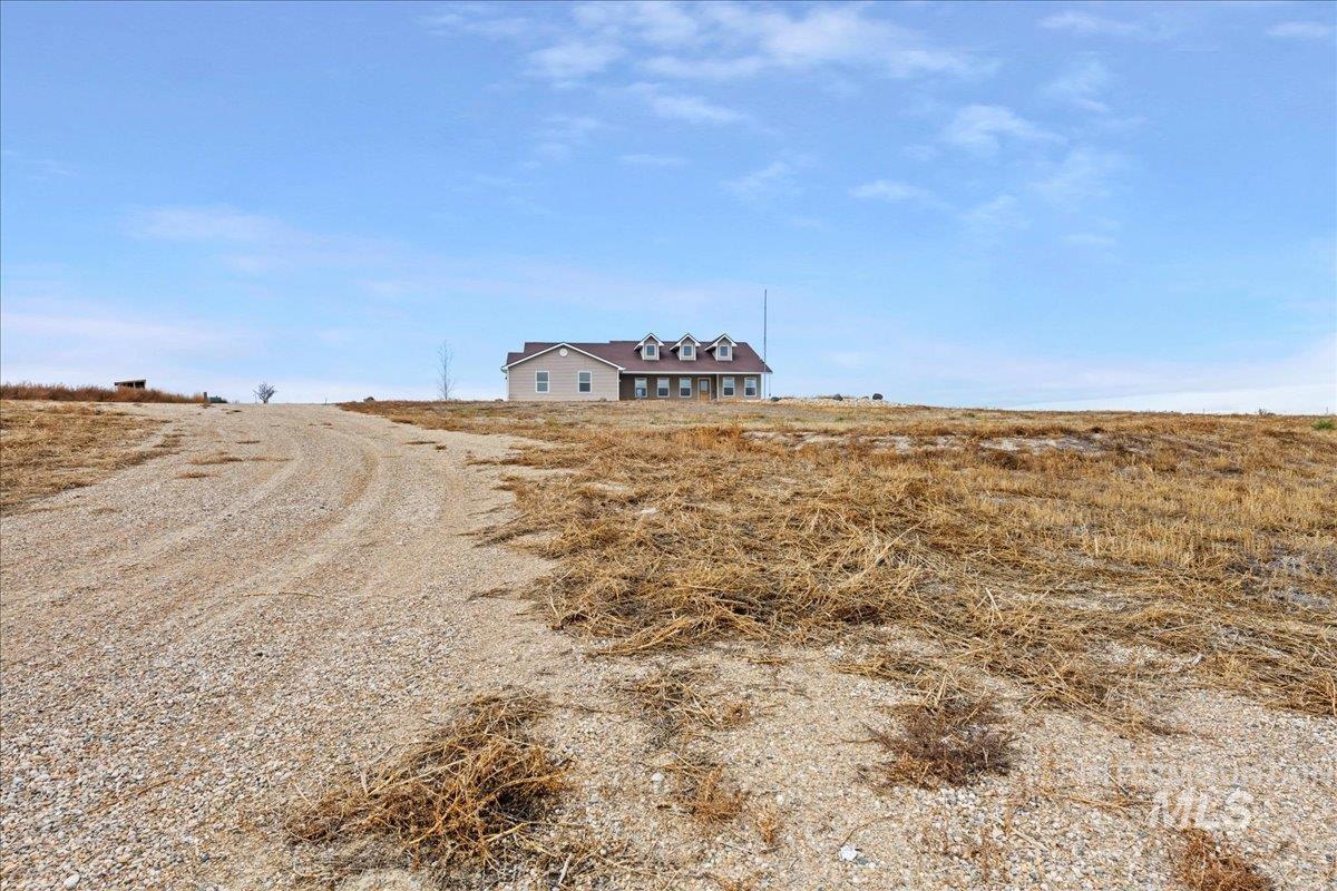 View of dirt / gravel driveway with a view of countryside
