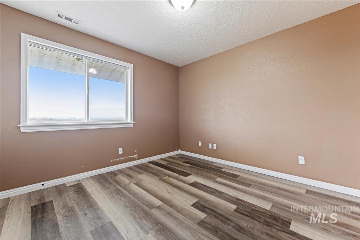 Spare room with light wood-style flooring and a textured ceiling