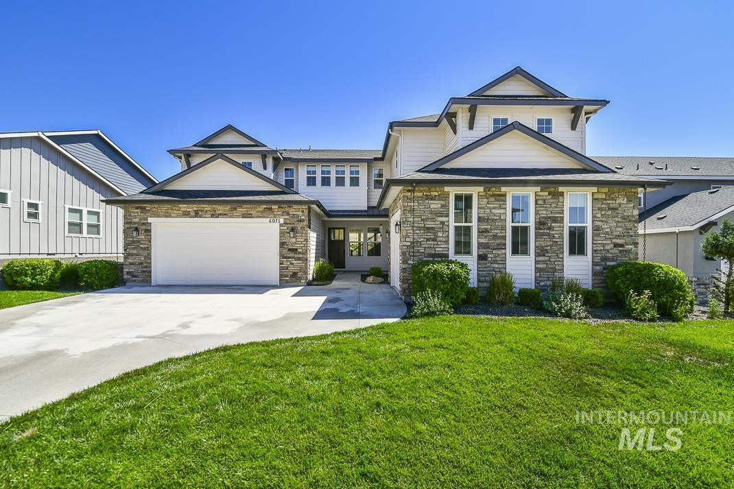 Craftsman house with concrete driveway, an attached garage, stone siding, and a front yard